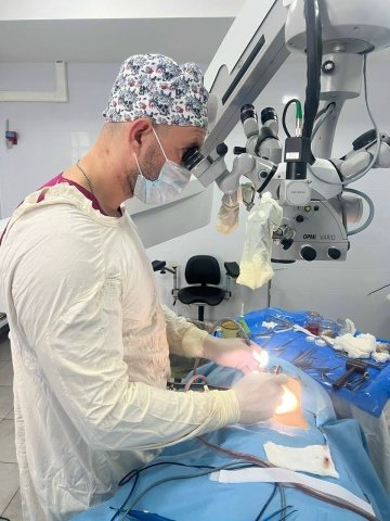 Хирург у операционного микроскопа